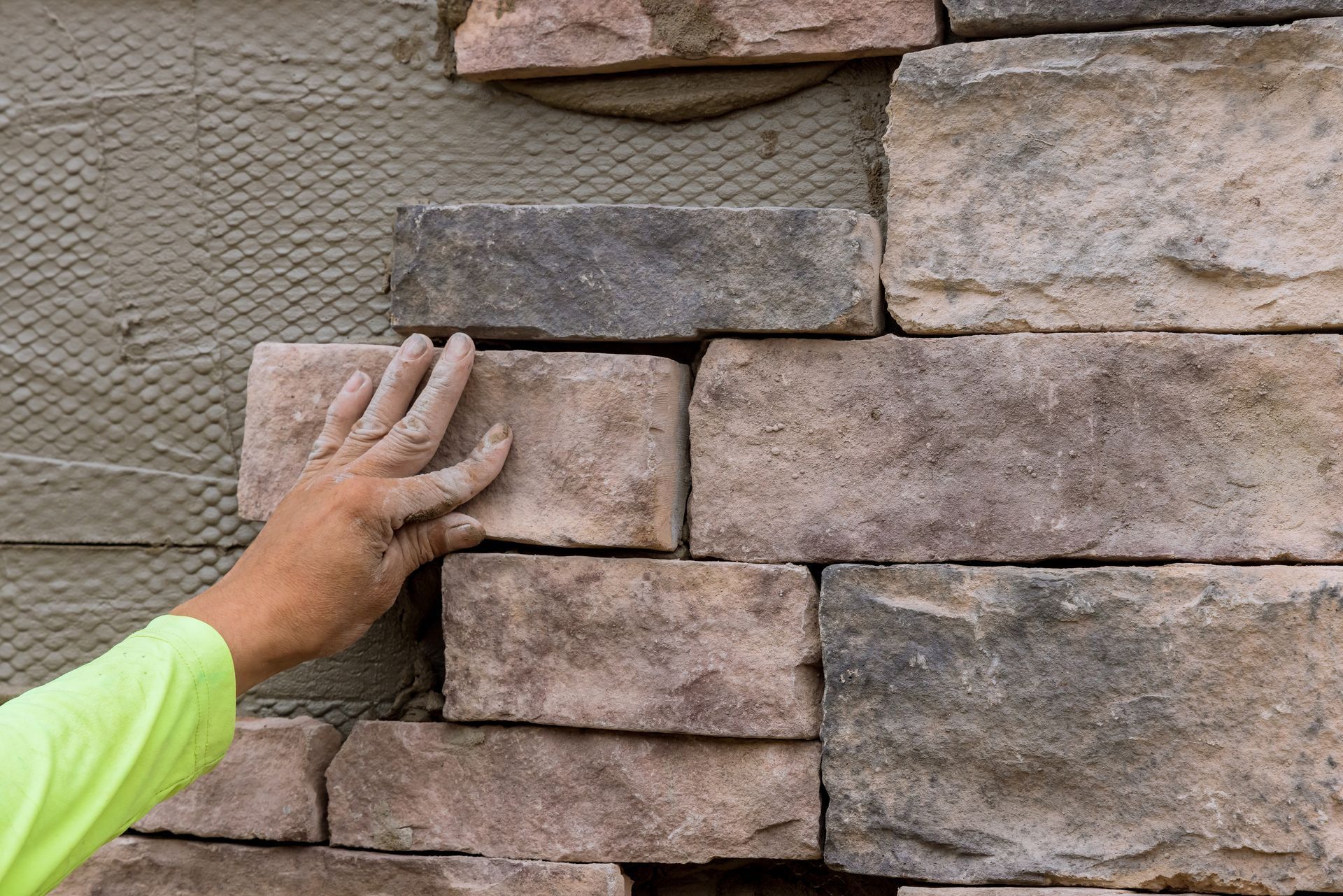 Une personne met des briques sur un mur.