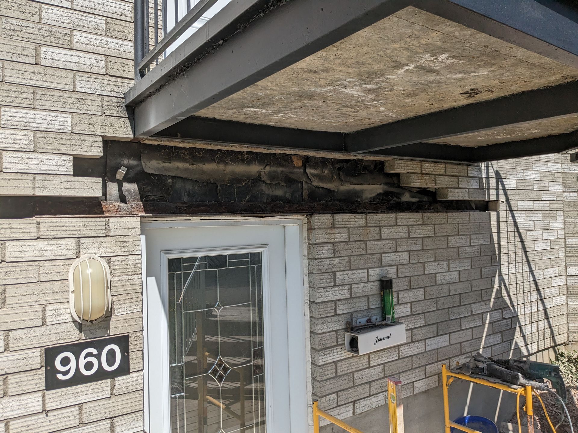 Un bâtiment en briques avec un balcon et des escaliers en construction.