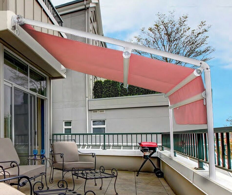 Tenda da sole retrattile rosa sopra un patio con sedie, tavolo e ringhiera del balcone con vista esterna