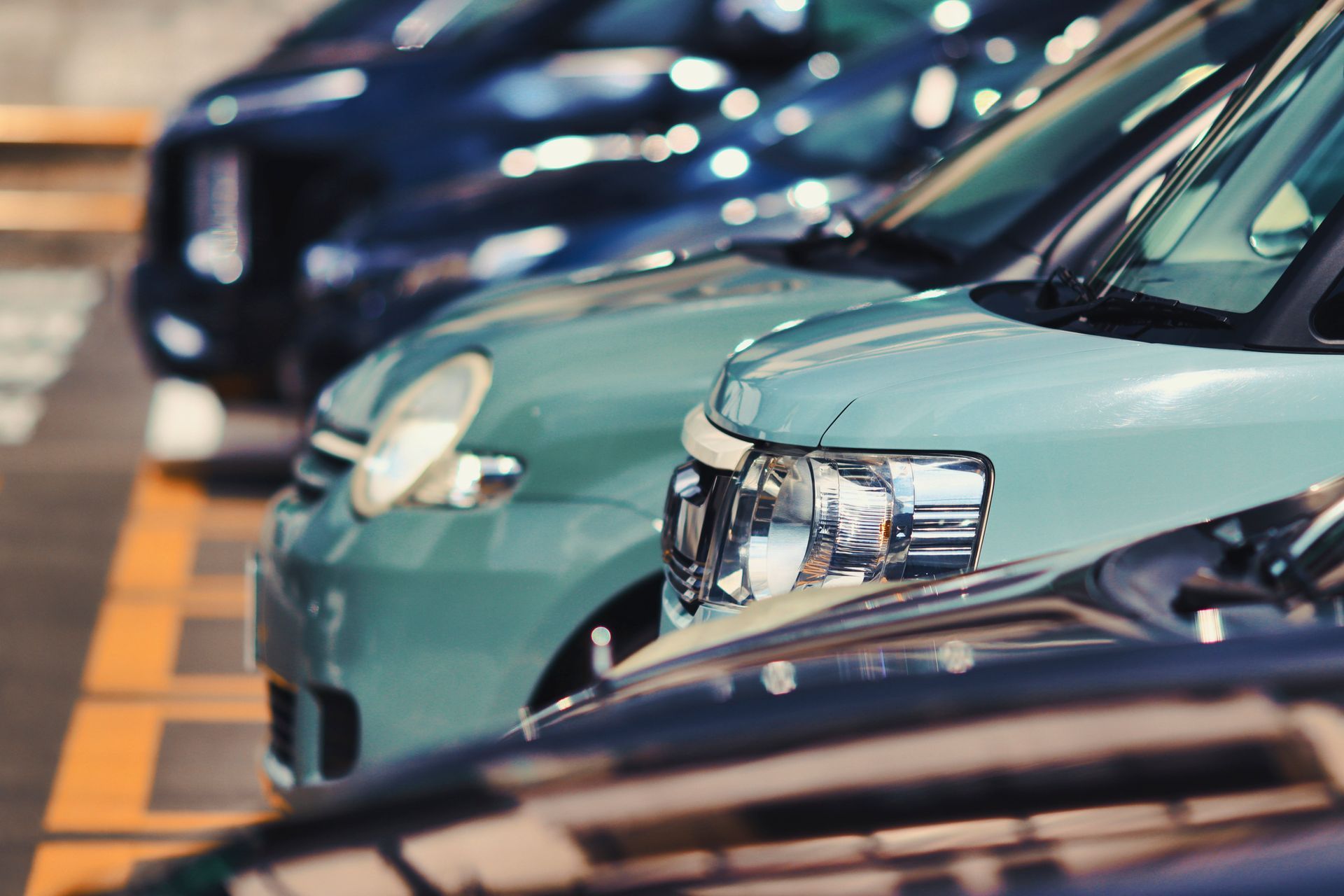 una fila di auto parcheggiate uno accanto all'altro in un parcheggio
