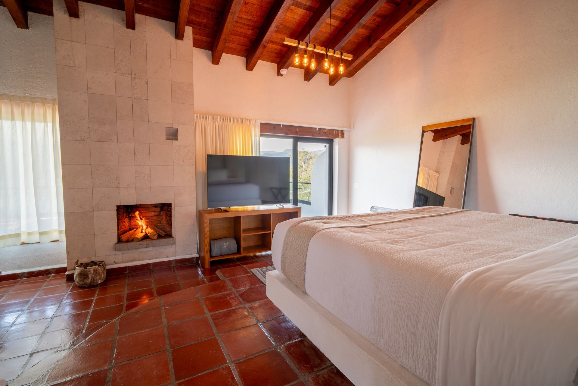 Un dormitorio con cama, televisión, chimenea y espejo en Hanna Hotel Boutique