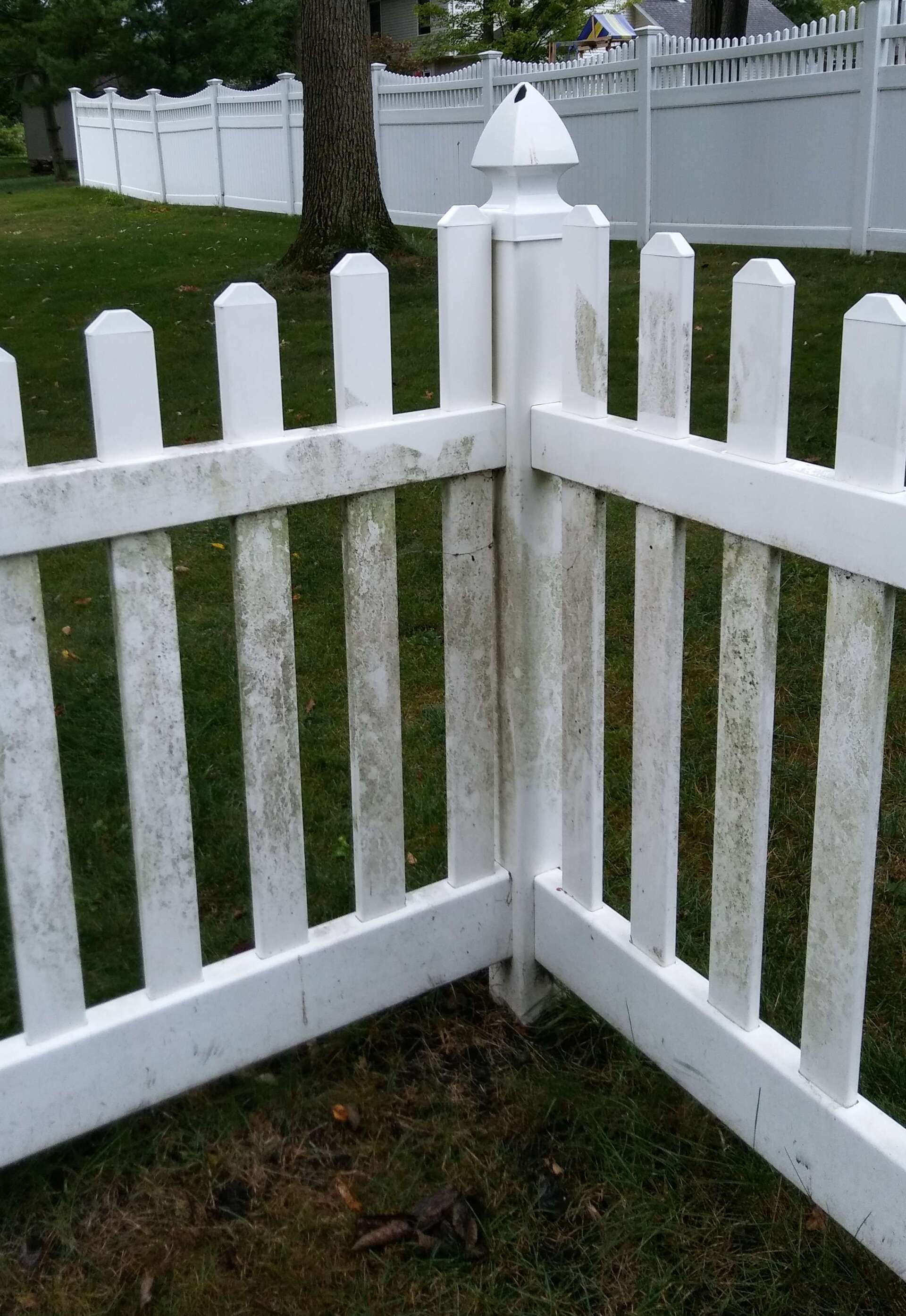 A white picket fence is sitting in the grass