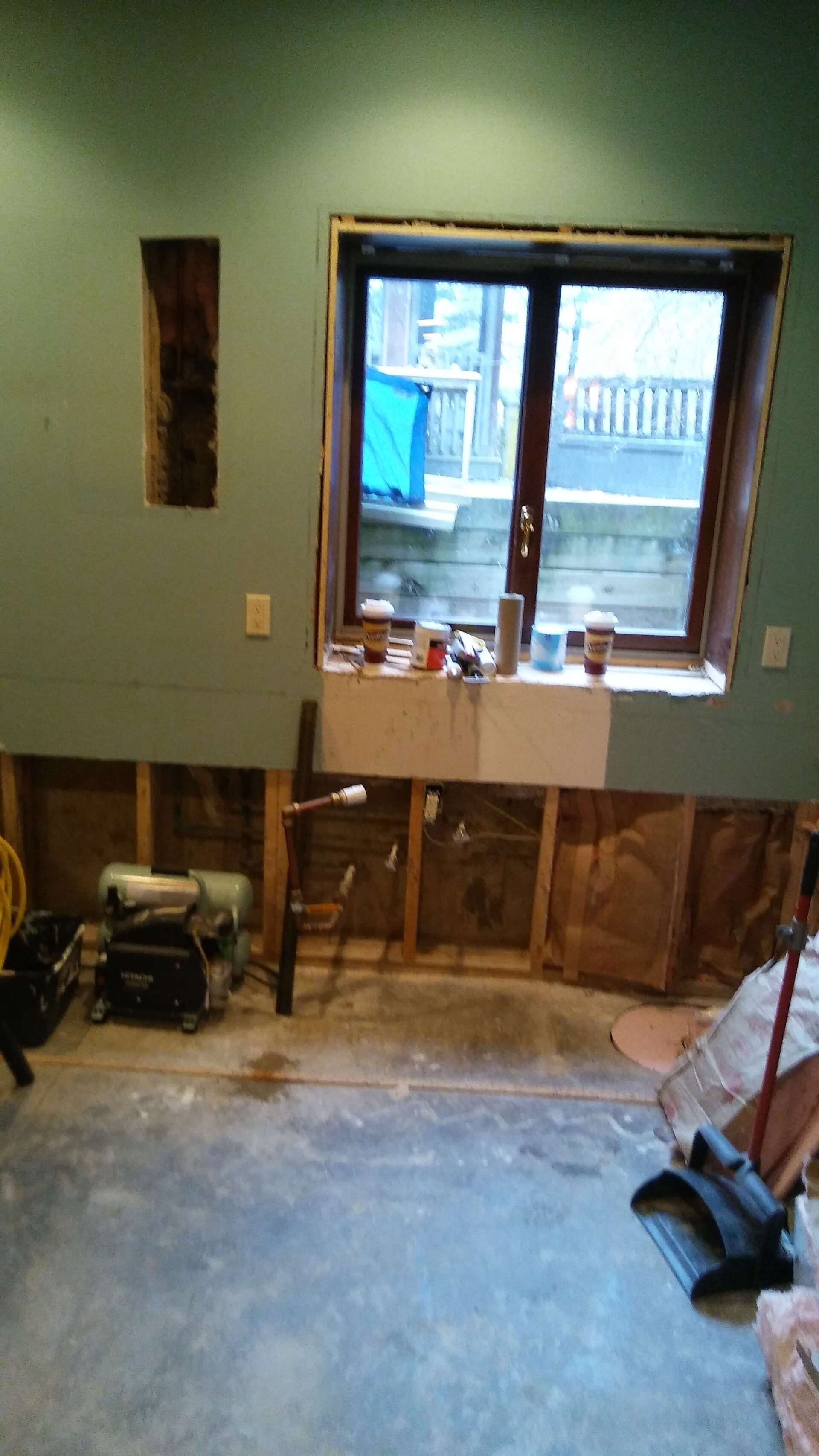 A room with a window and a sink in it.