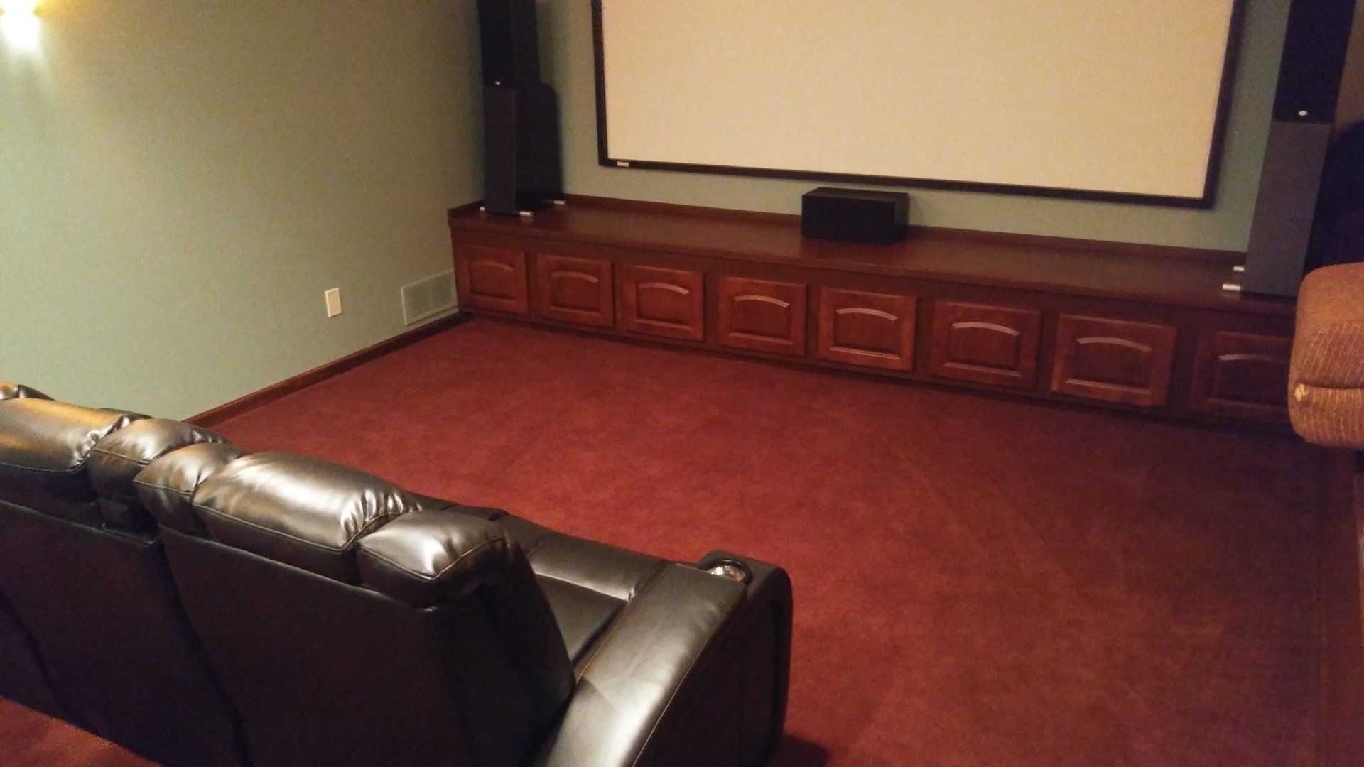 A home theater with a projector screen and a couch.