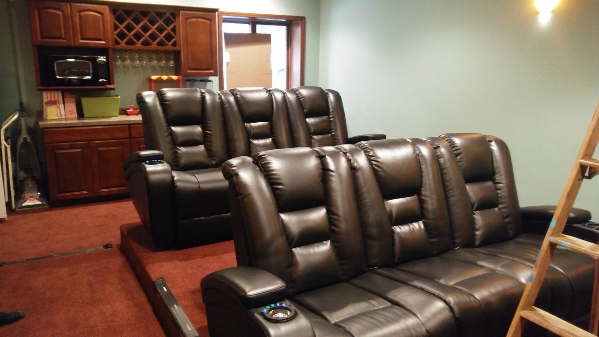 A home theater with a ladder and a couch