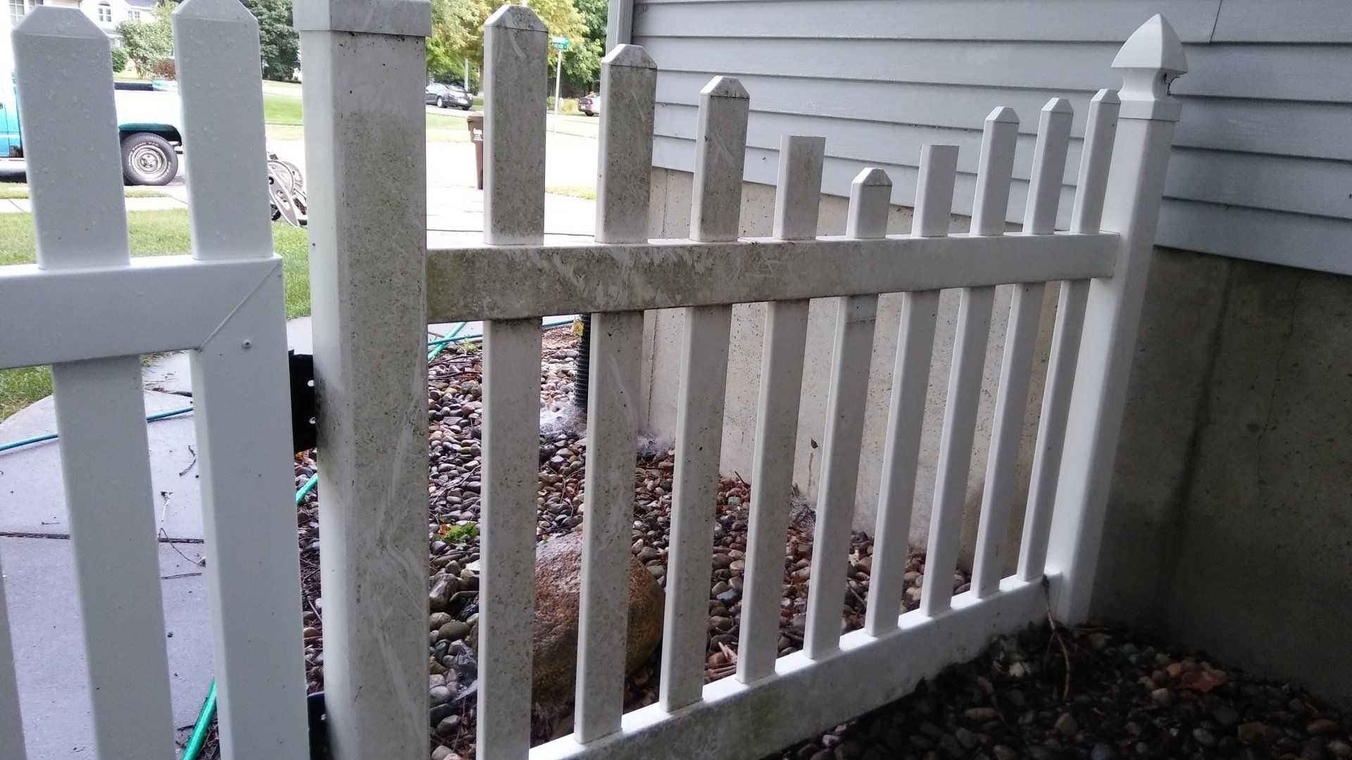 A white picket fence is sitting next to a house.