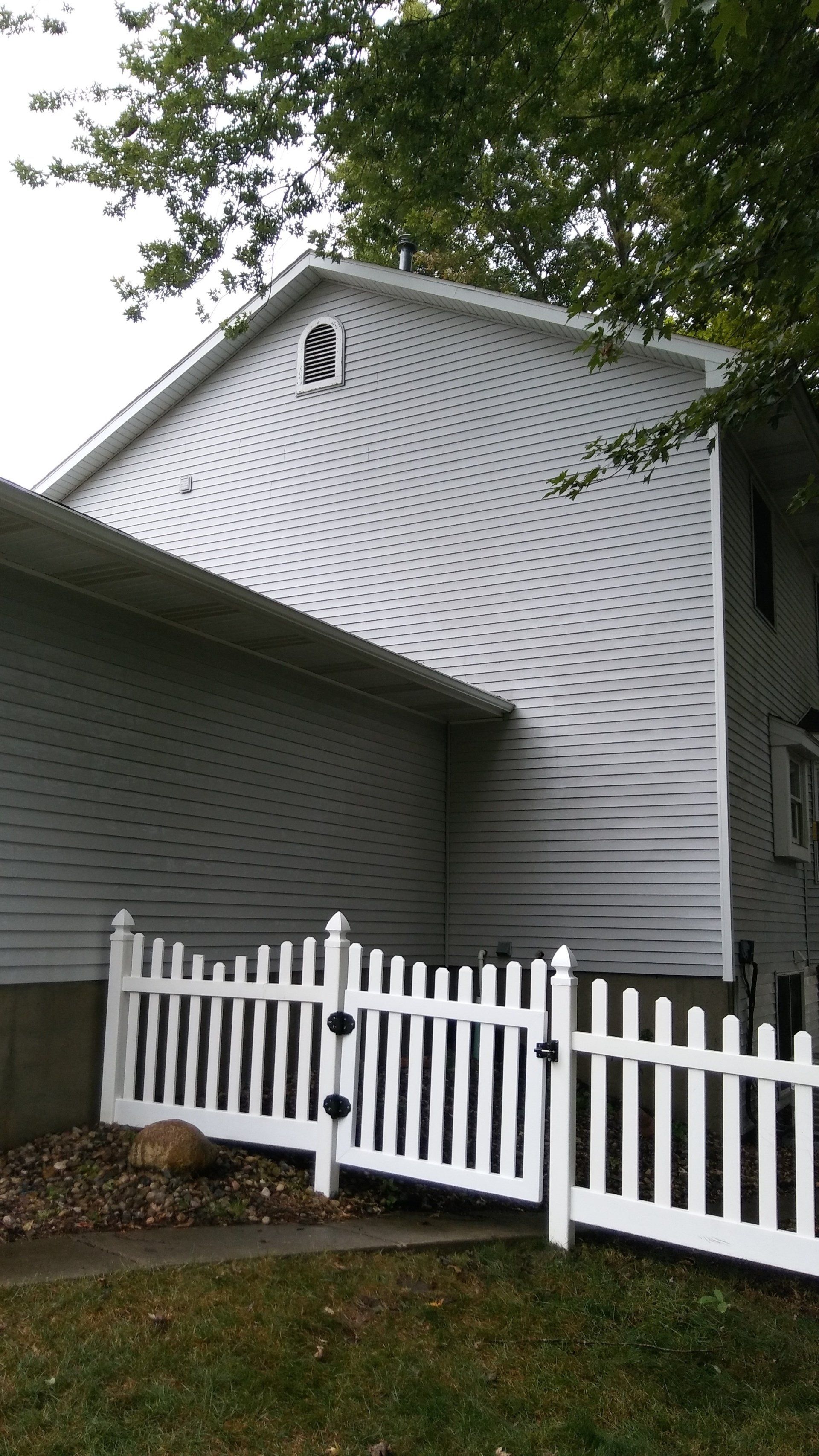 A white house with a white picket fence in front of it.