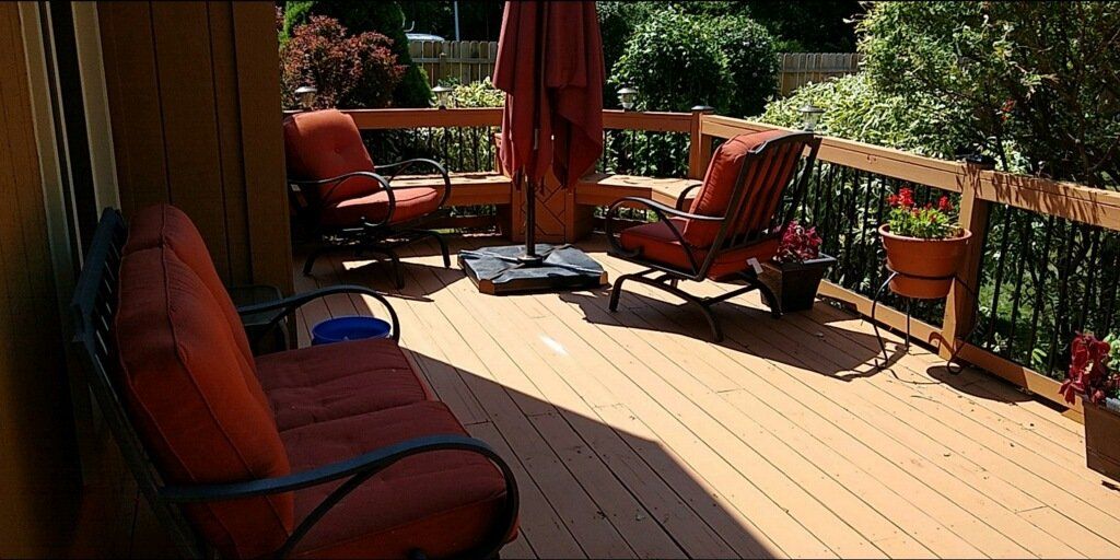 A wooden deck with chairs and umbrellas on it