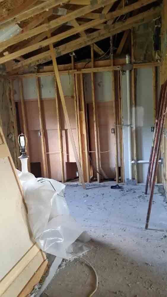 A room with wooden beams and a ladder in it.
