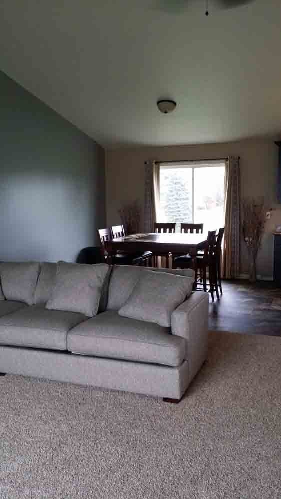 A living room with a couch , table and chairs.