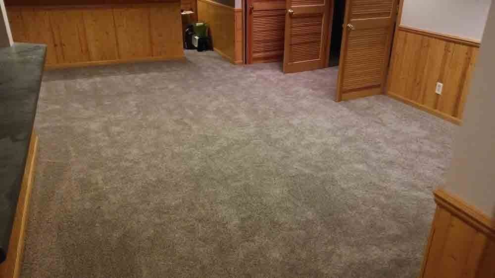 A room with a carpeted floor and wood paneling.