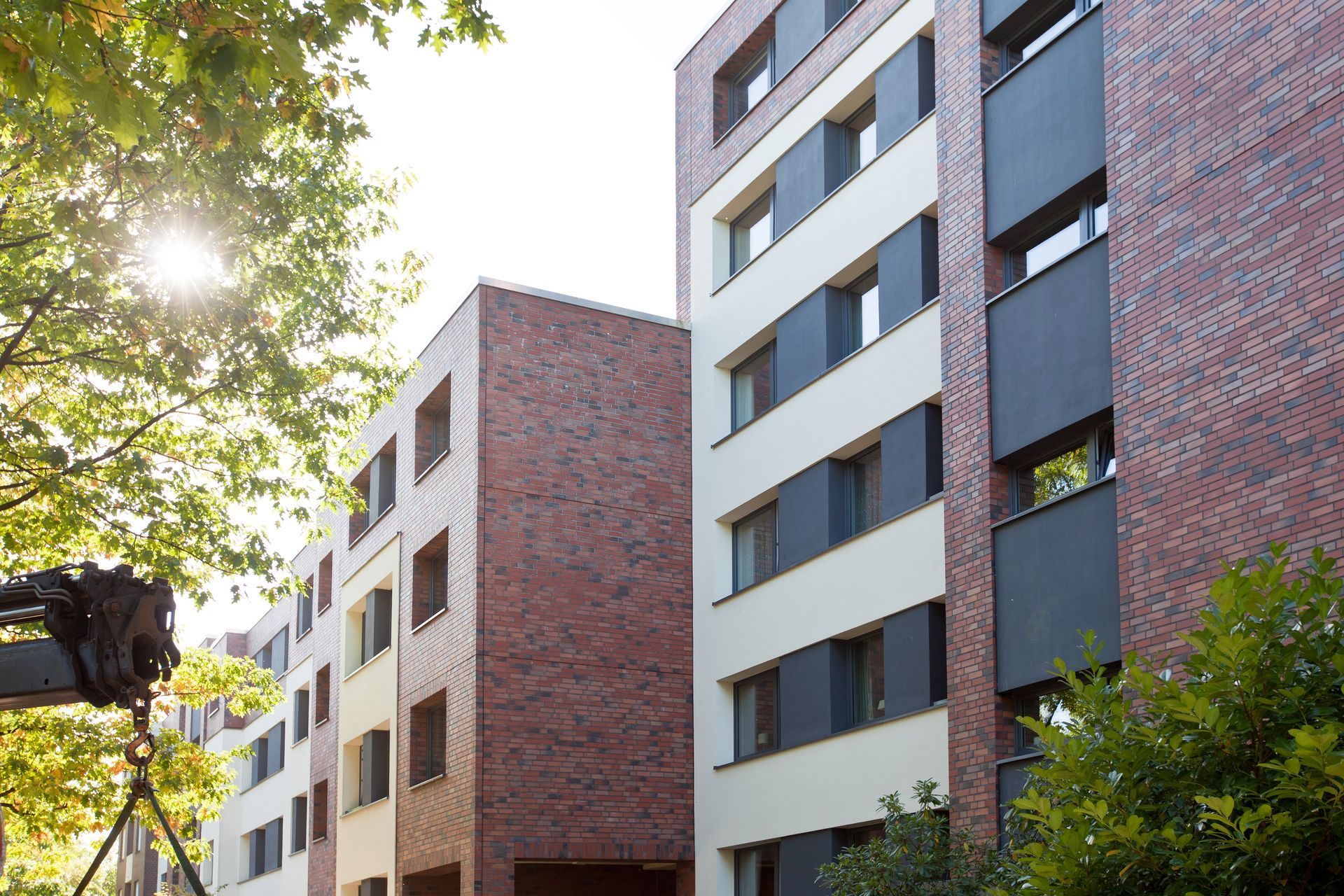 Ein großes Gebäude mit Klinkerfront mit einer Kamera auf einem Stativ davor