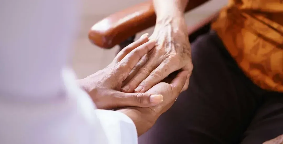 A close-up of a person holding another person's hand.