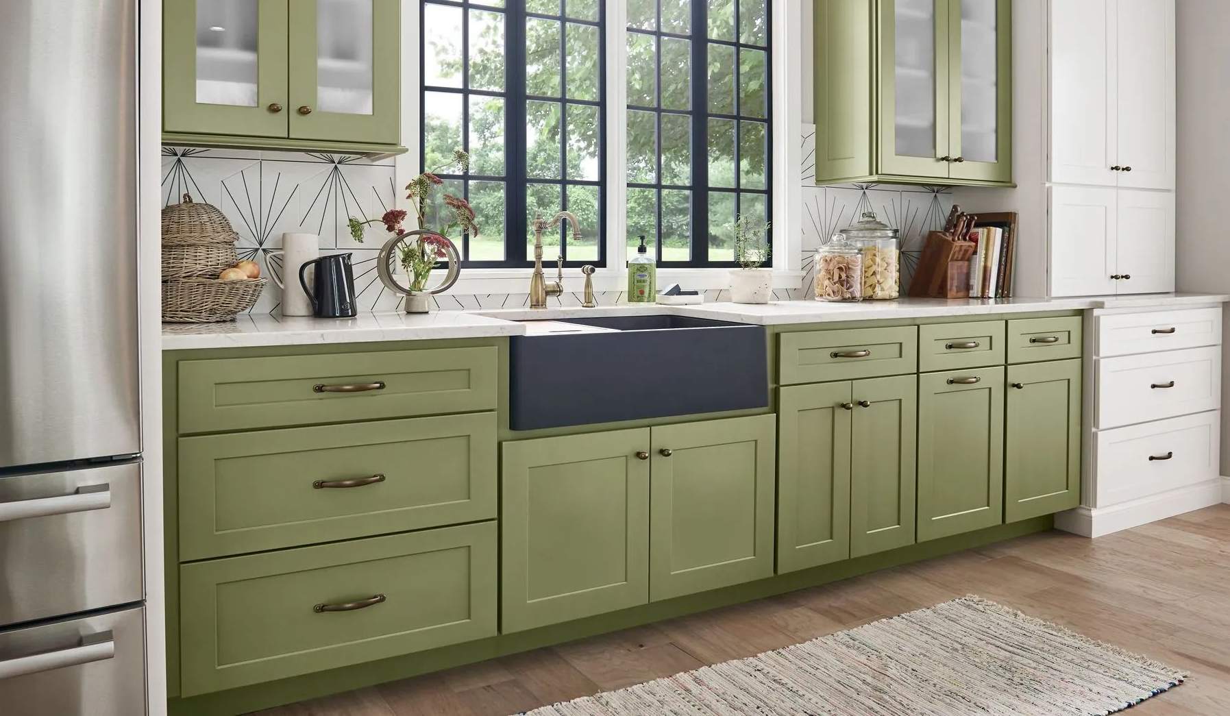 Olive green kitchen cabinets with white countertops and large windows in a bright modern kitchen
