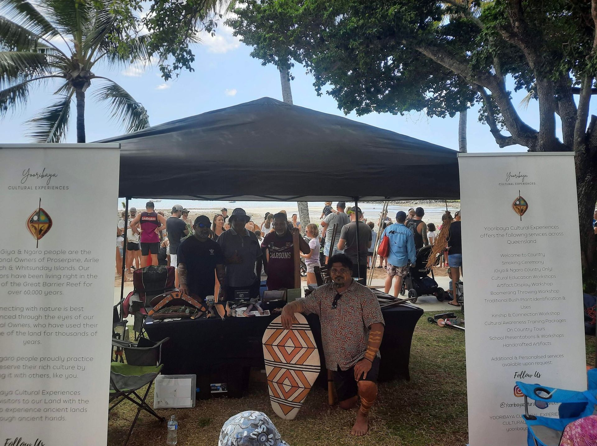 A group of people are standing around a table under a tent.