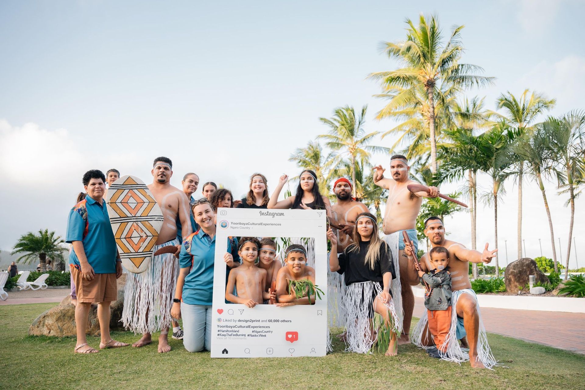 A large group of people are posing for a picture in front of a instagram frame.