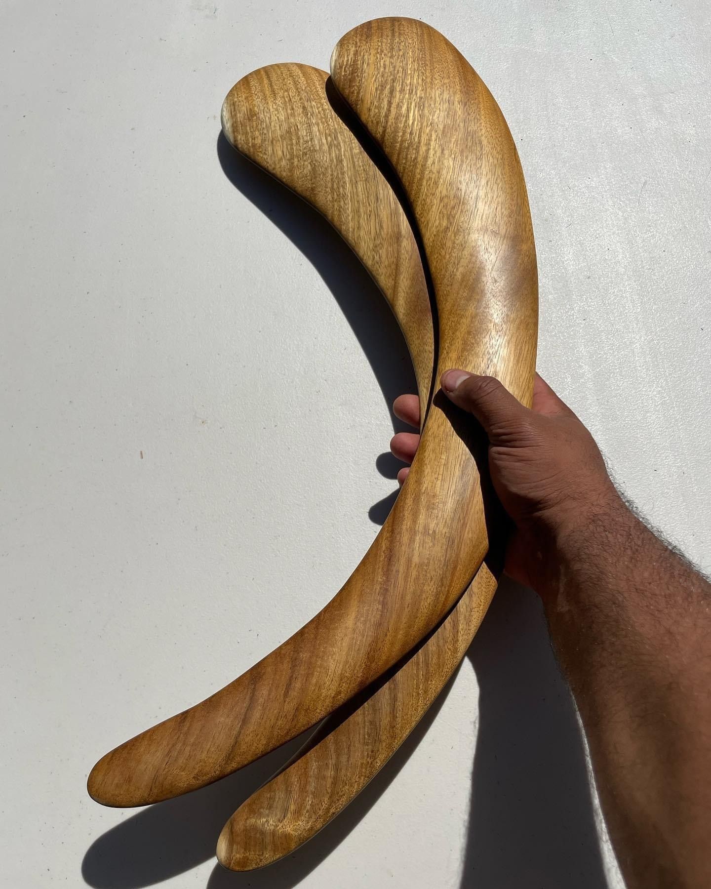 A person is holding two wooden sticks in their hand