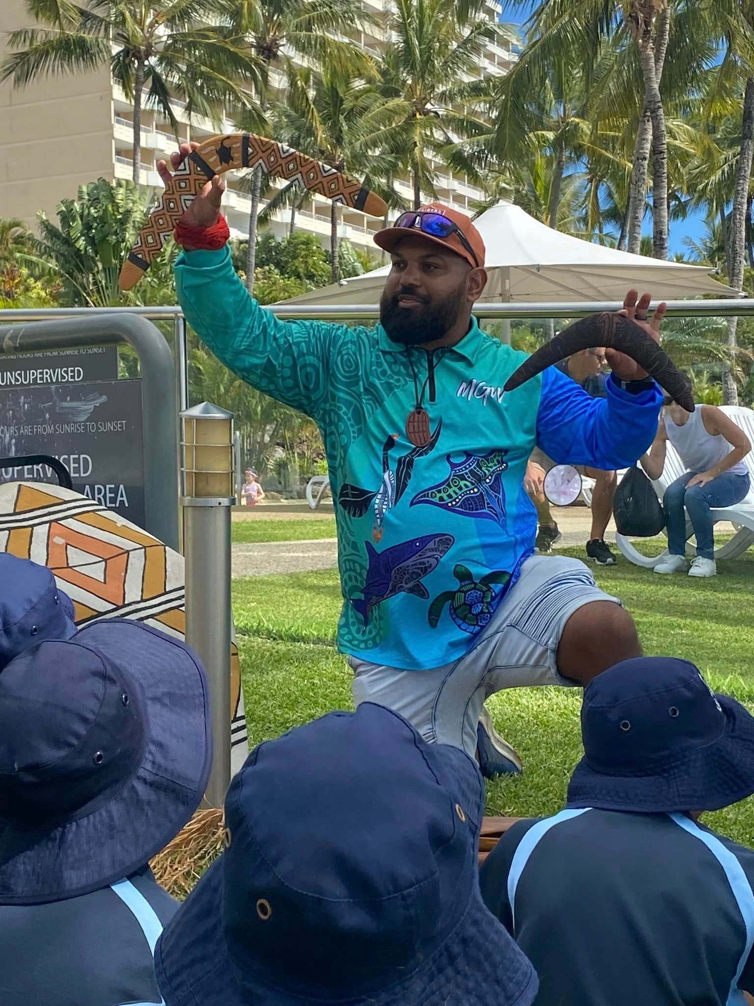 A man is holding a snake in his hand in front of a group of people.