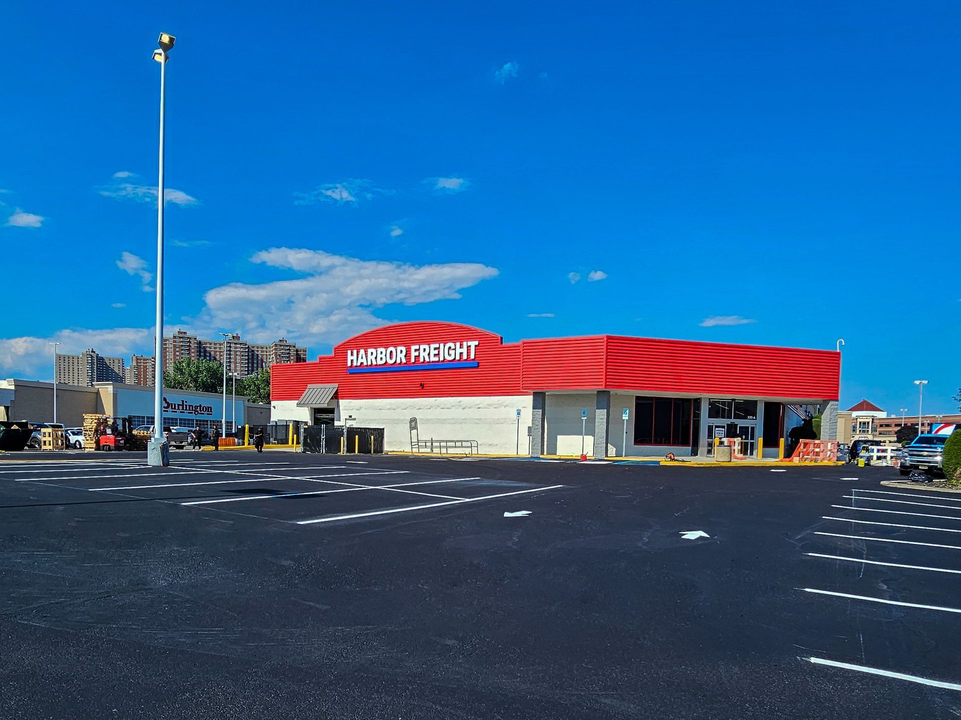Waffle House restaurant with a red roof under a clear blue sky, seen across a mostly empty parking lot