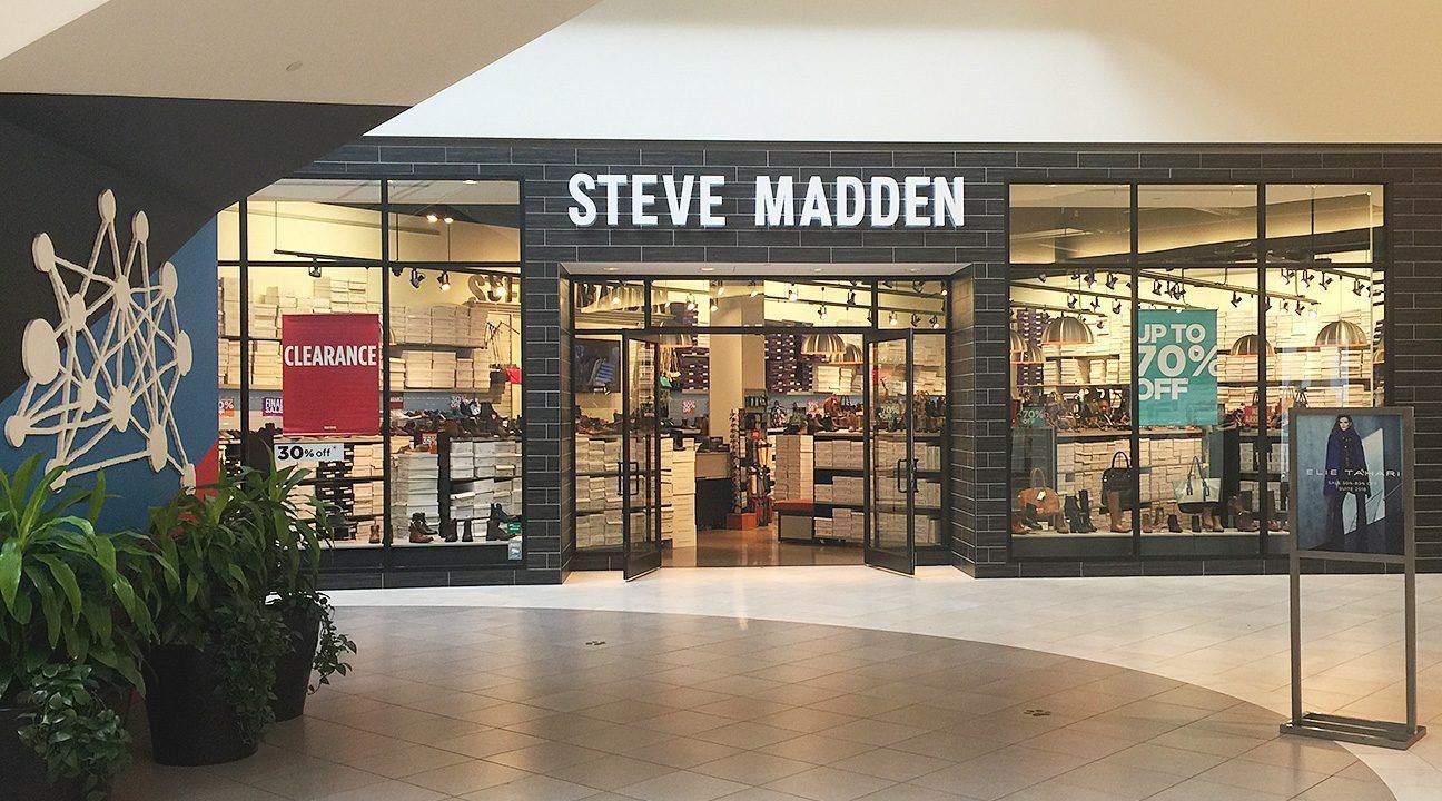 Steve Madden store entrance in a shopping mall, with glass doors and bright retail displays.