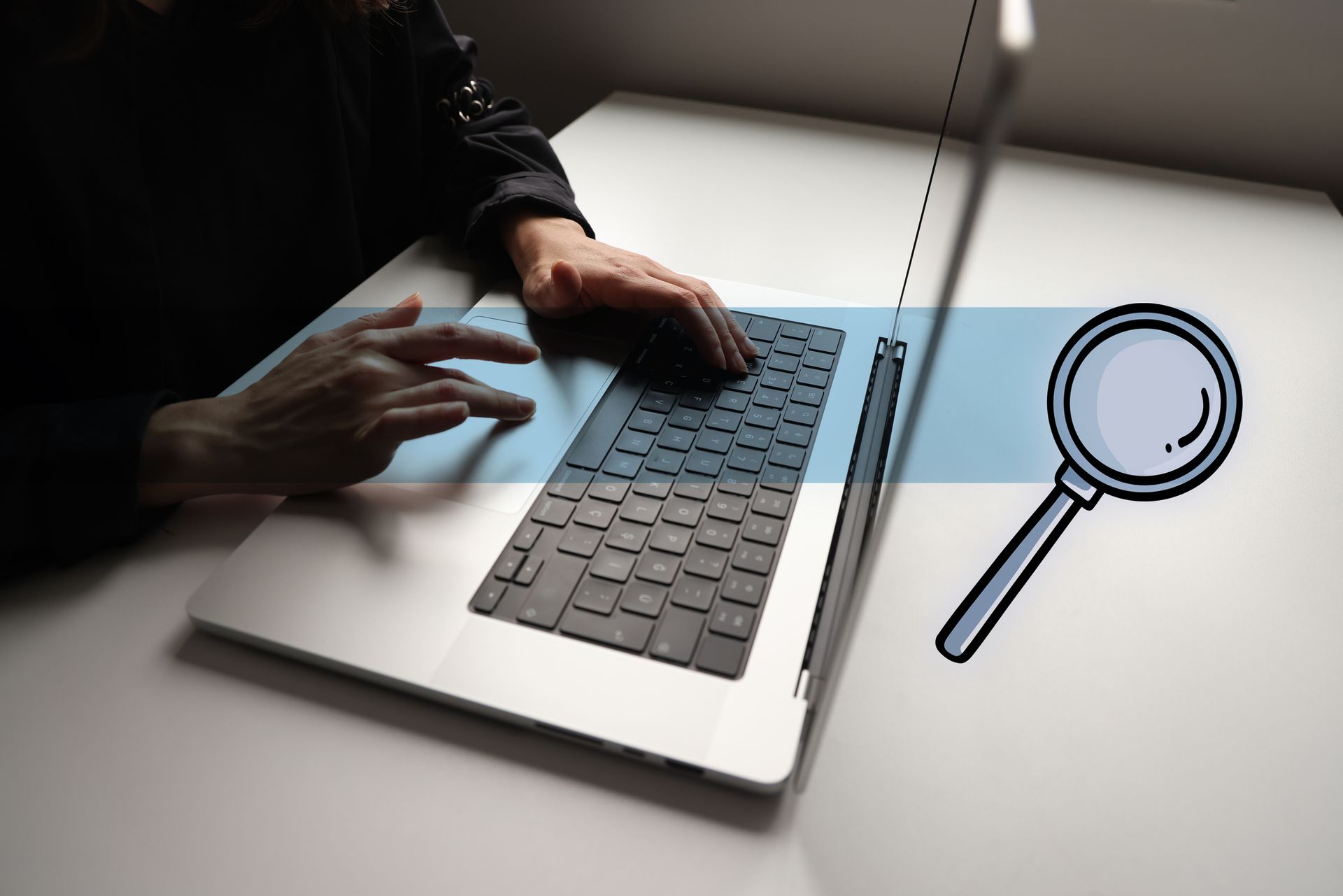 Close-up of a person performing an inmate research on a laptop, and a magnifying glass. Close-up of a person performing an inmate research on a laptop, and a magnifying glass.