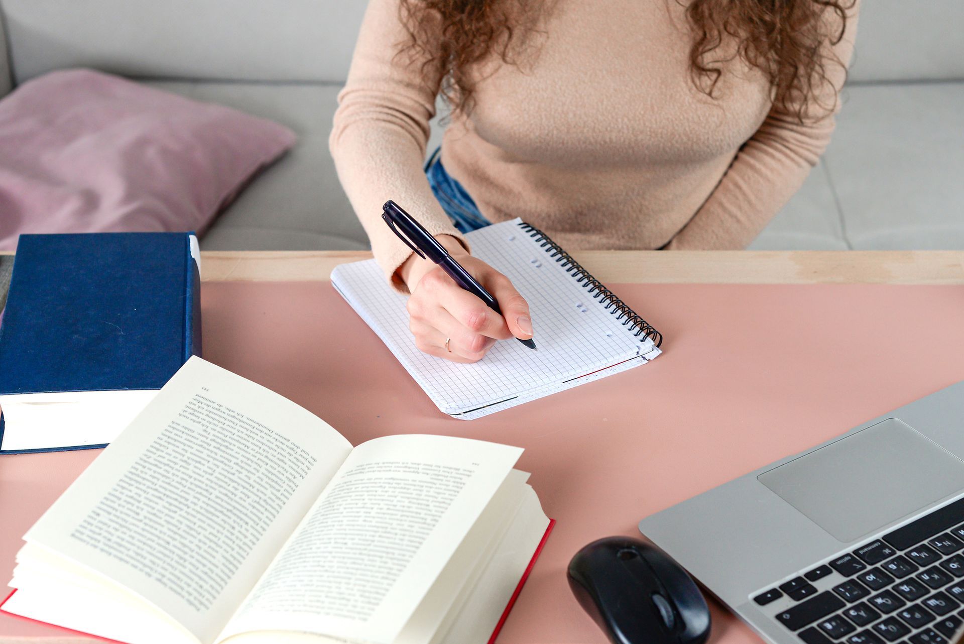 individual who is focused diligently taking notes while studying.