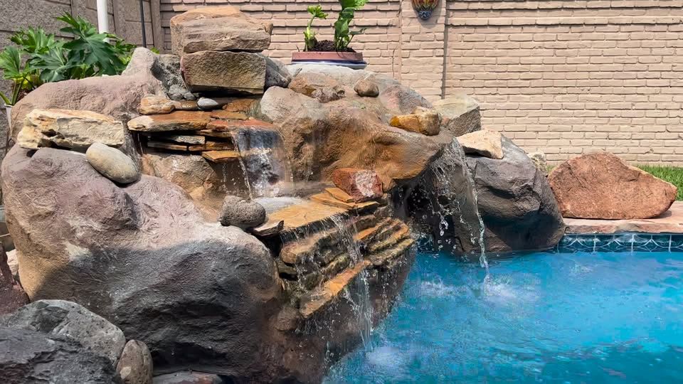 There is a large swimming pool in the backyard of a house.