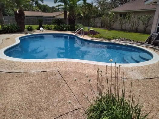 A man is painting a swimming pool with a roller.