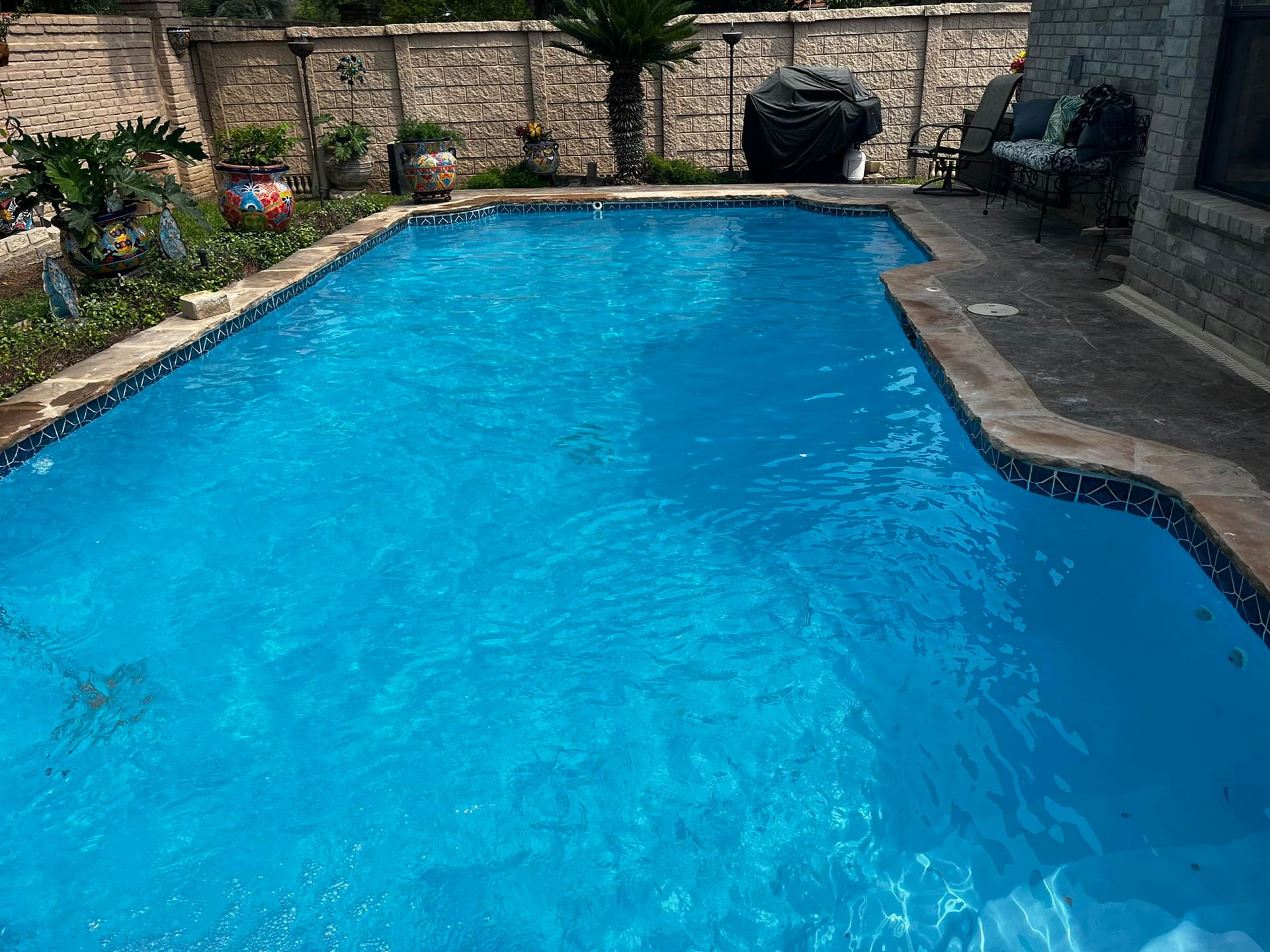 A man is cleaning a swimming pool with a vacuum cleaner.