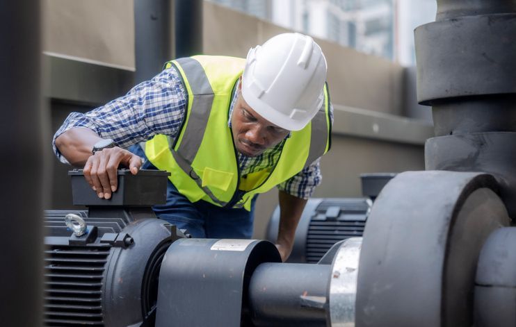 Engineer inspects a large industrial centrifugal pump. 