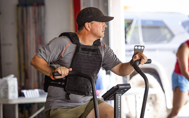 Man in a black cap and vest pulling battle ropes in Crabtrap Functional Fitness a gym in Thibodaux, LA, training area.
