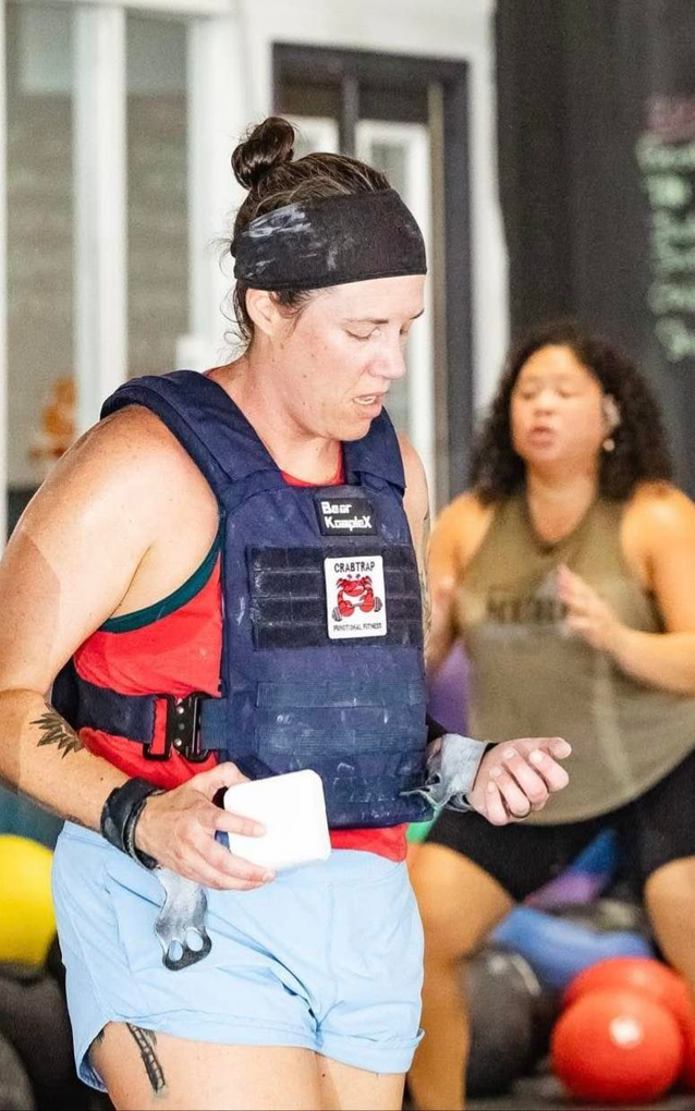 Woman in workout gear holding a cup during an indoor fitness class in Crabtrap Functional Fitness a gym in Thibodaux, LA