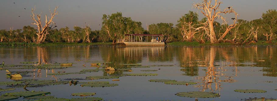 A boat is floating on top of a lake surrounded by trees.