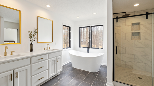 Bright modern bathroom with double vanity, freestanding tub, and glass-enclosed shower