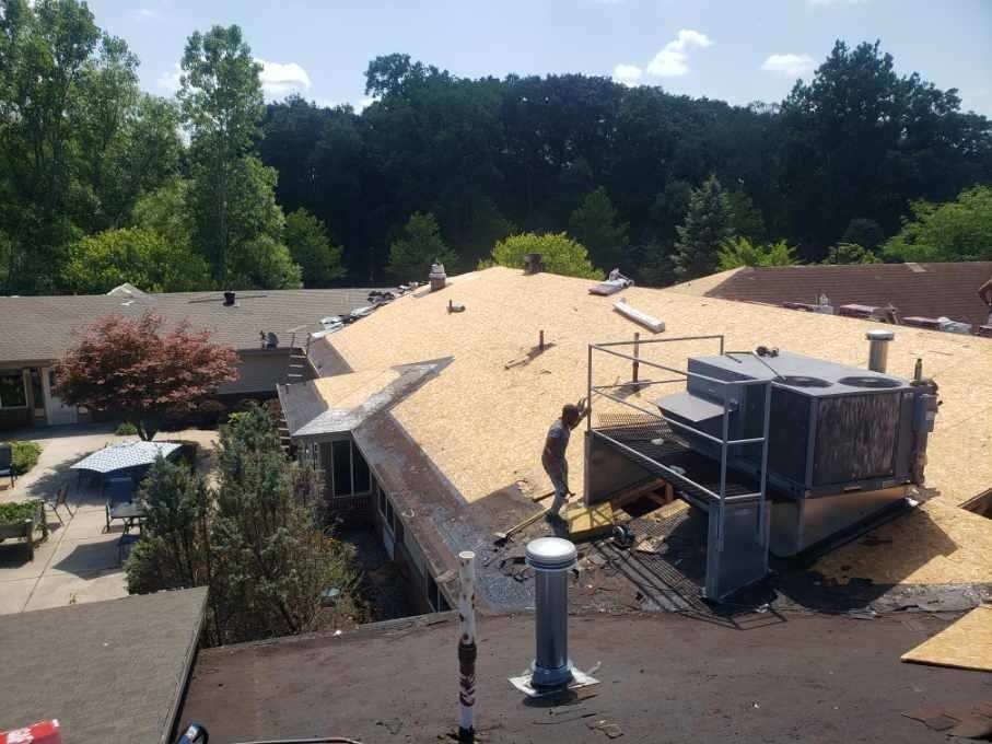 Damaged rooftop with torn shingles and exposed structure after storm damage