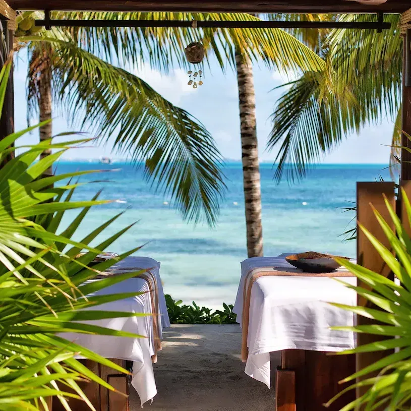 Two massage tables on the beach with a view of the ocean