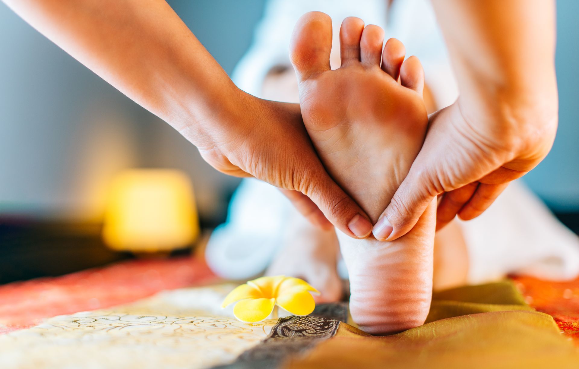 Hawaiian reflexology foot massage with plumeria flower
