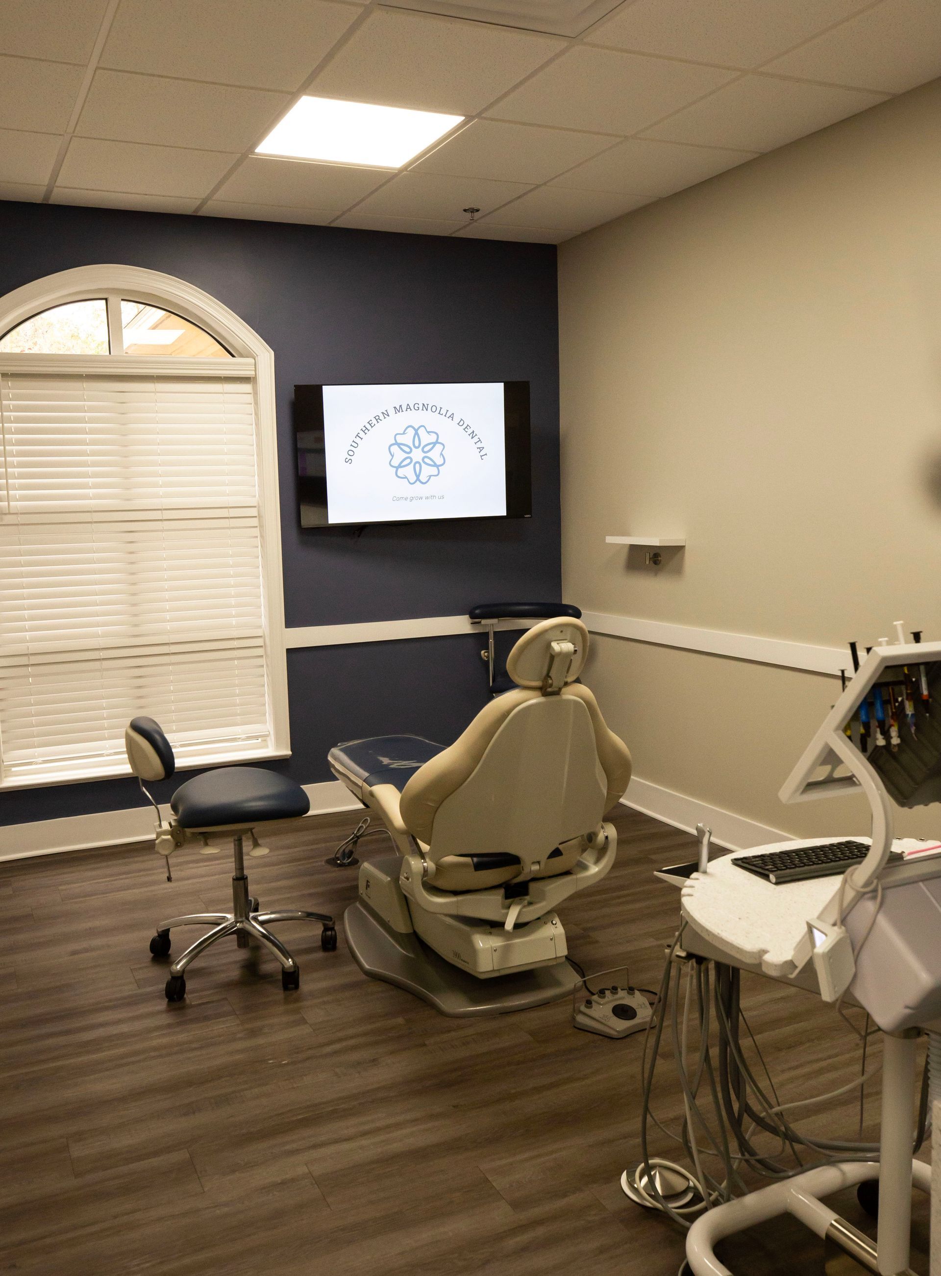 Southern Magnolia Dental logo in white on a blue background; a floral design and tagline.