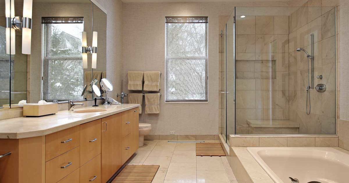 A bathroom with two sinks , a tub , a shower and two mirrors.