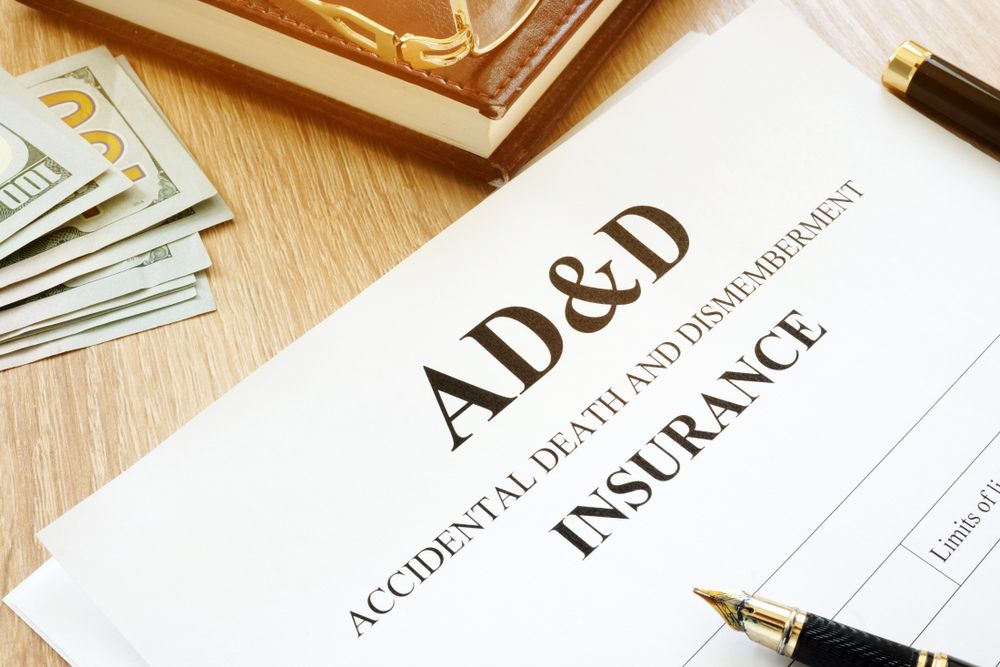 AD&D accidental death and dismemberment insurance form on a desk with pen and cash bills