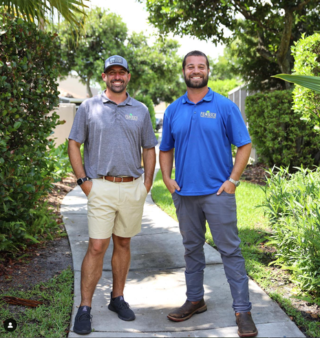 Two men are standing next to each other on a sidewalk