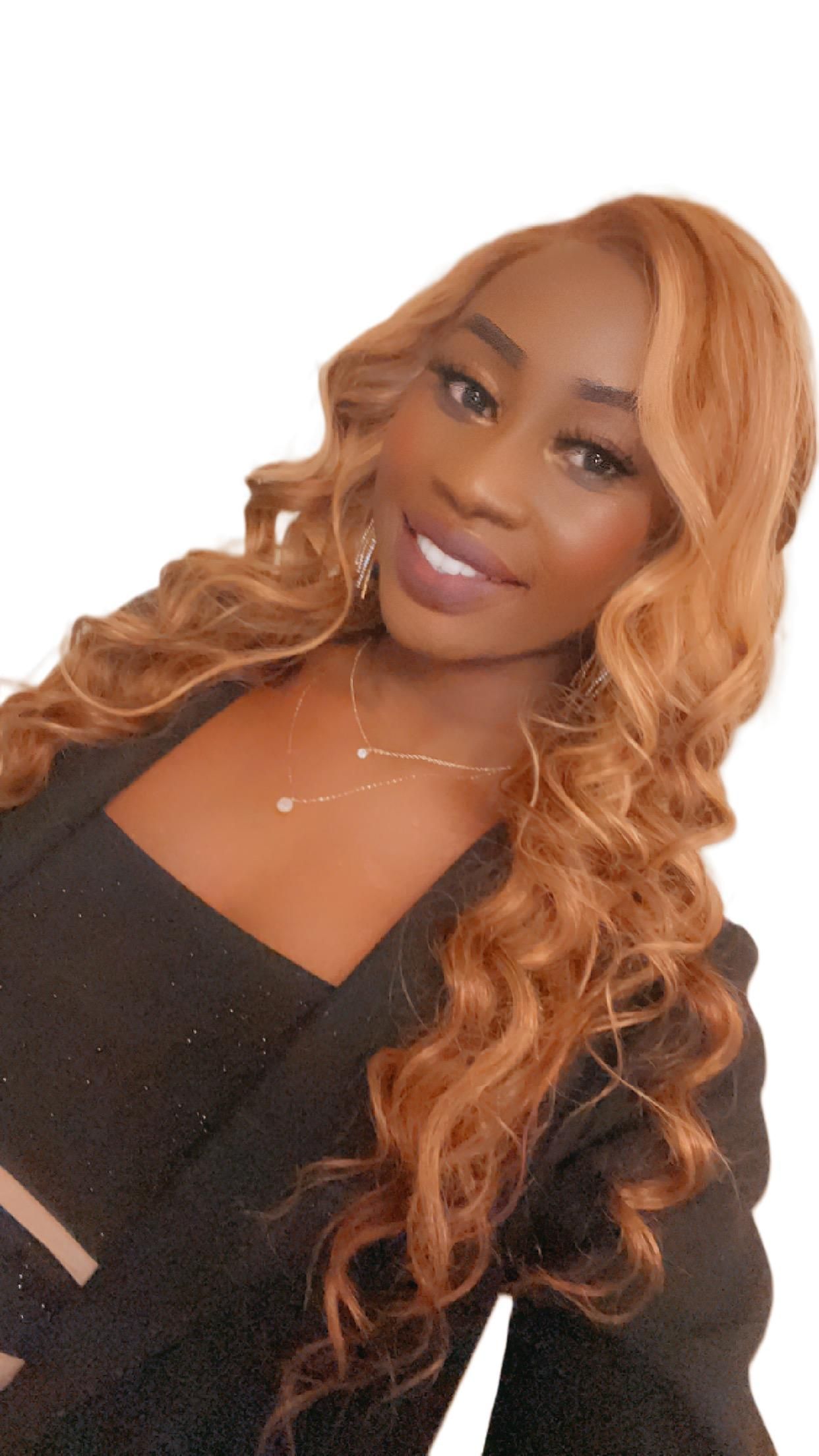 Woman with long, wavy auburn hair, wearing a black top, smiling.