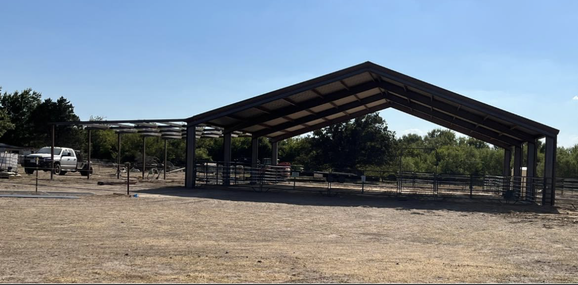 A large metal structure is sitting in the middle of a dirt field.