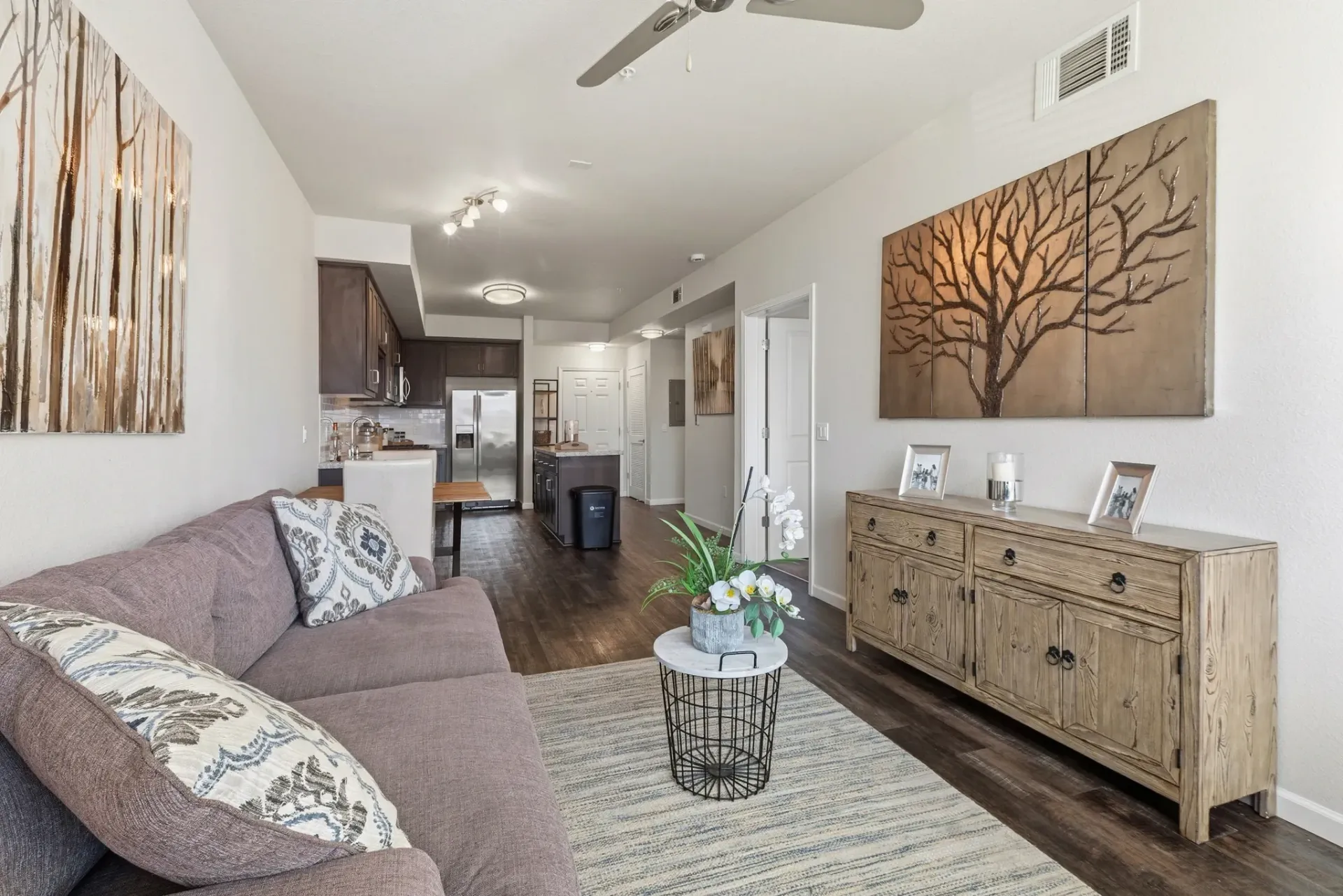 Modern living room with gray sofa, coffee table, and open-concept kitchen.