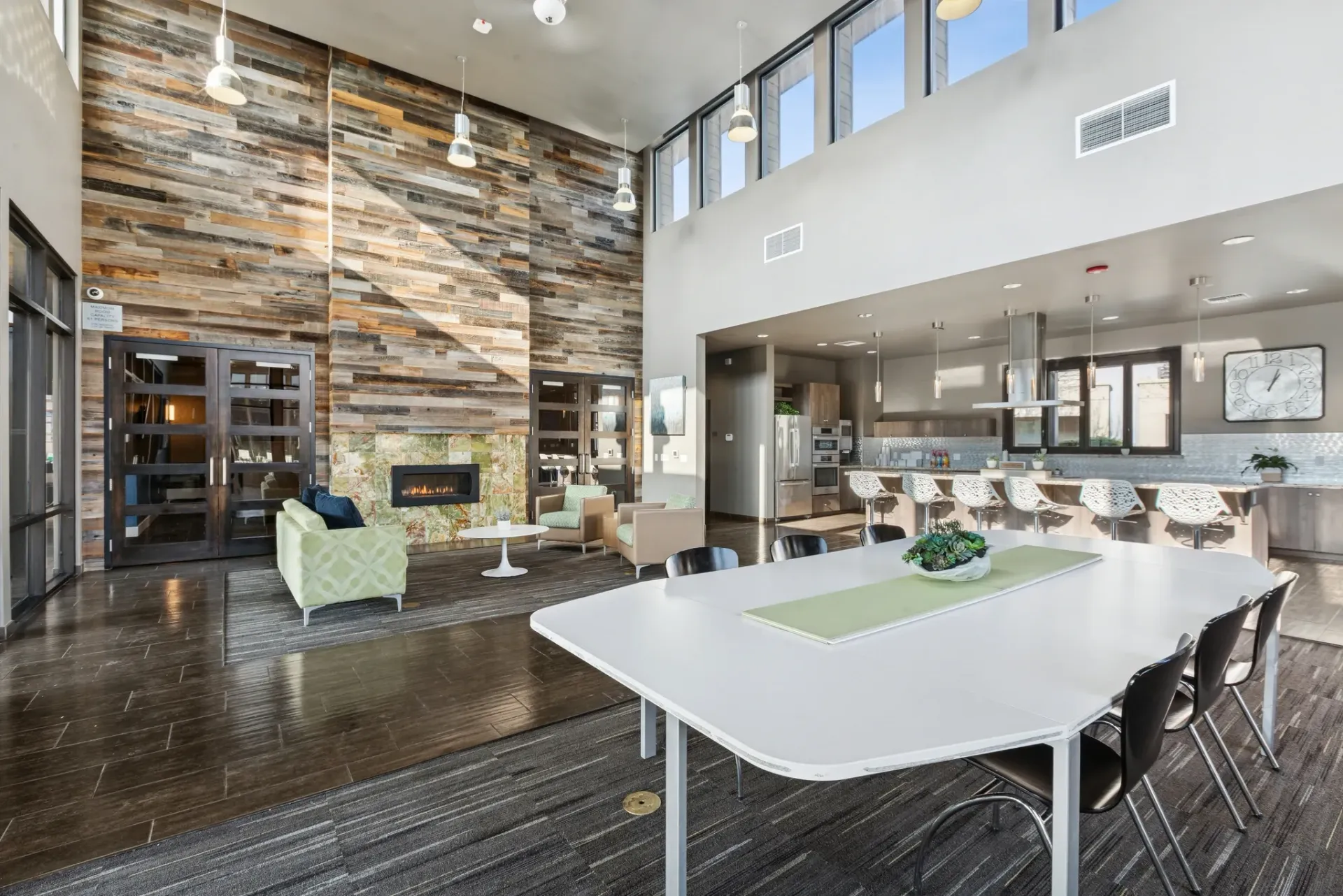 Spacious lounge area with a fireplace, modern kitchen, and large dining table.