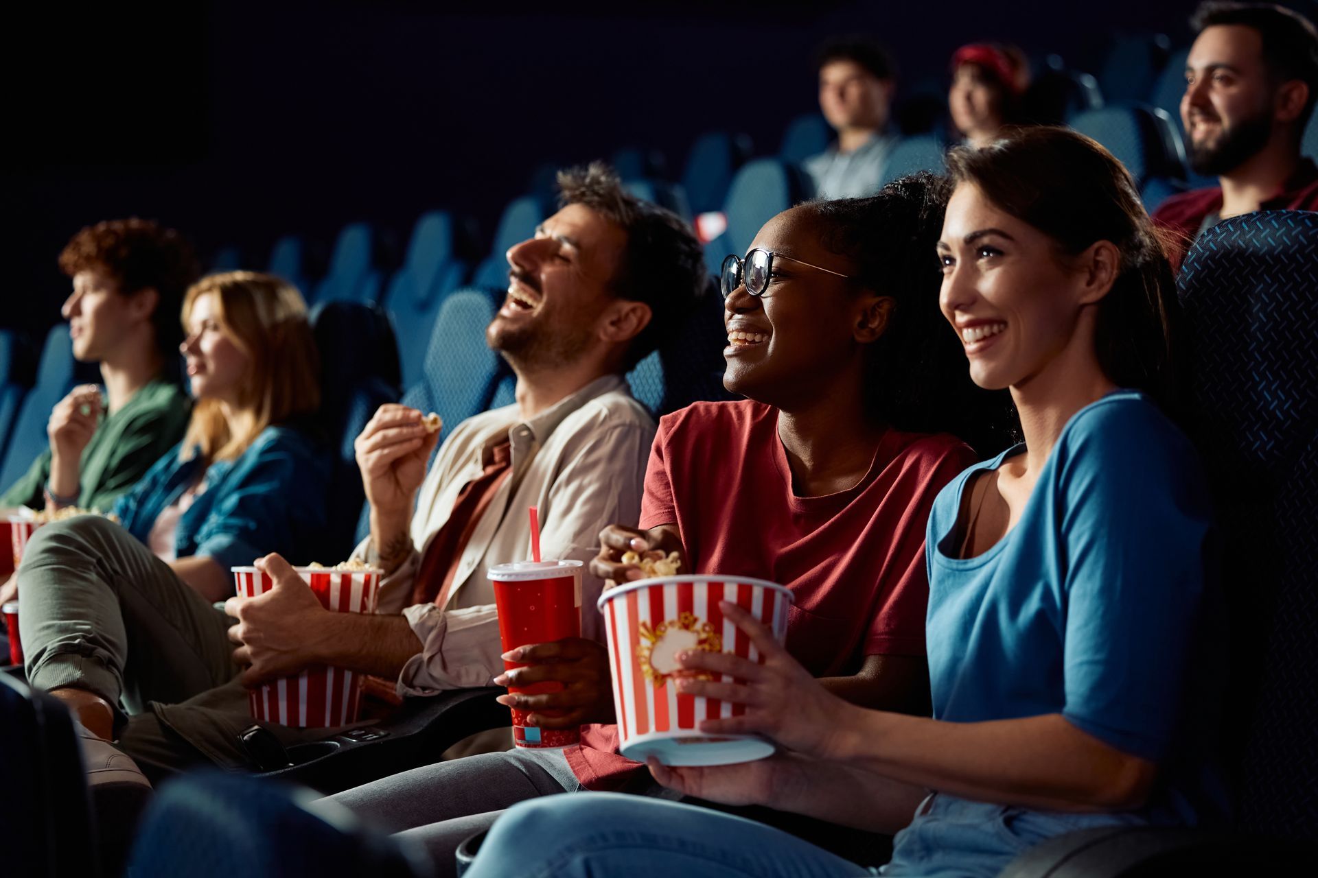 A group of people enjoying a movie at the movie theater.