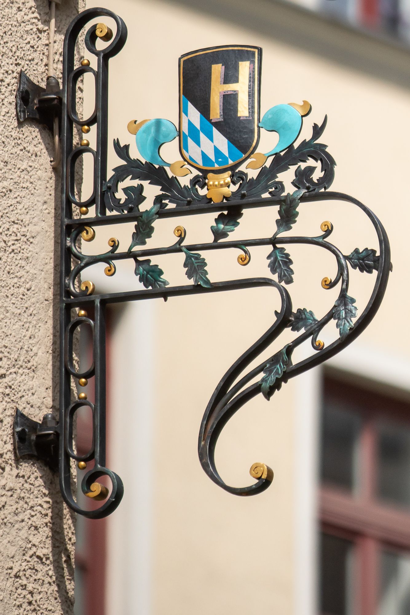 Black, ornate sign with shield featuring