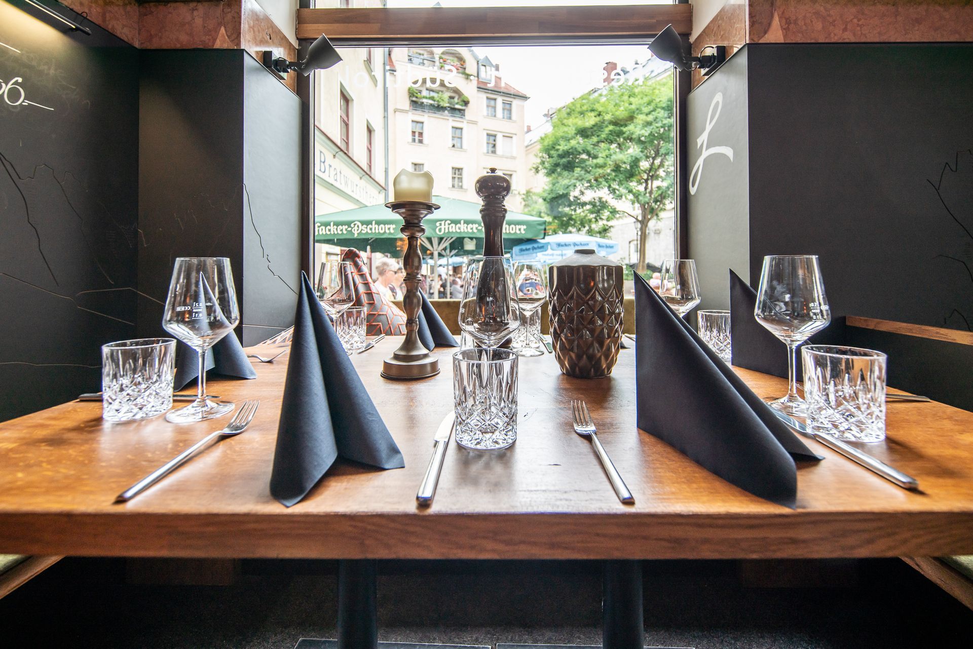 Table set for a meal at a restaurant, with view of street outside window.