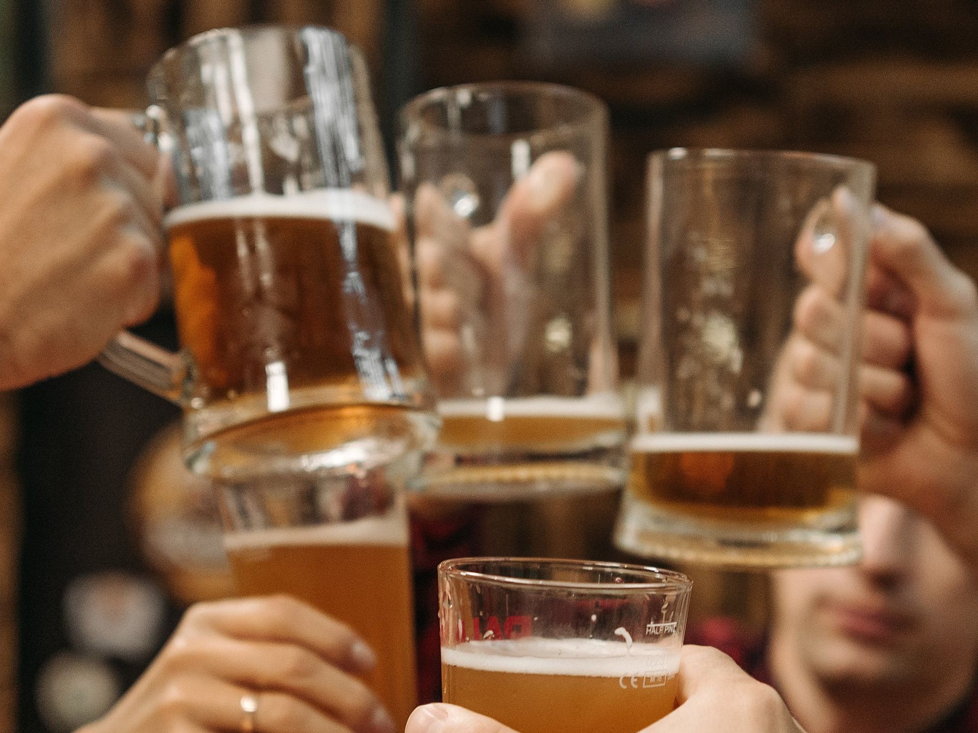 Cheers: Hands holding beer mugs and glasses, clinking together.