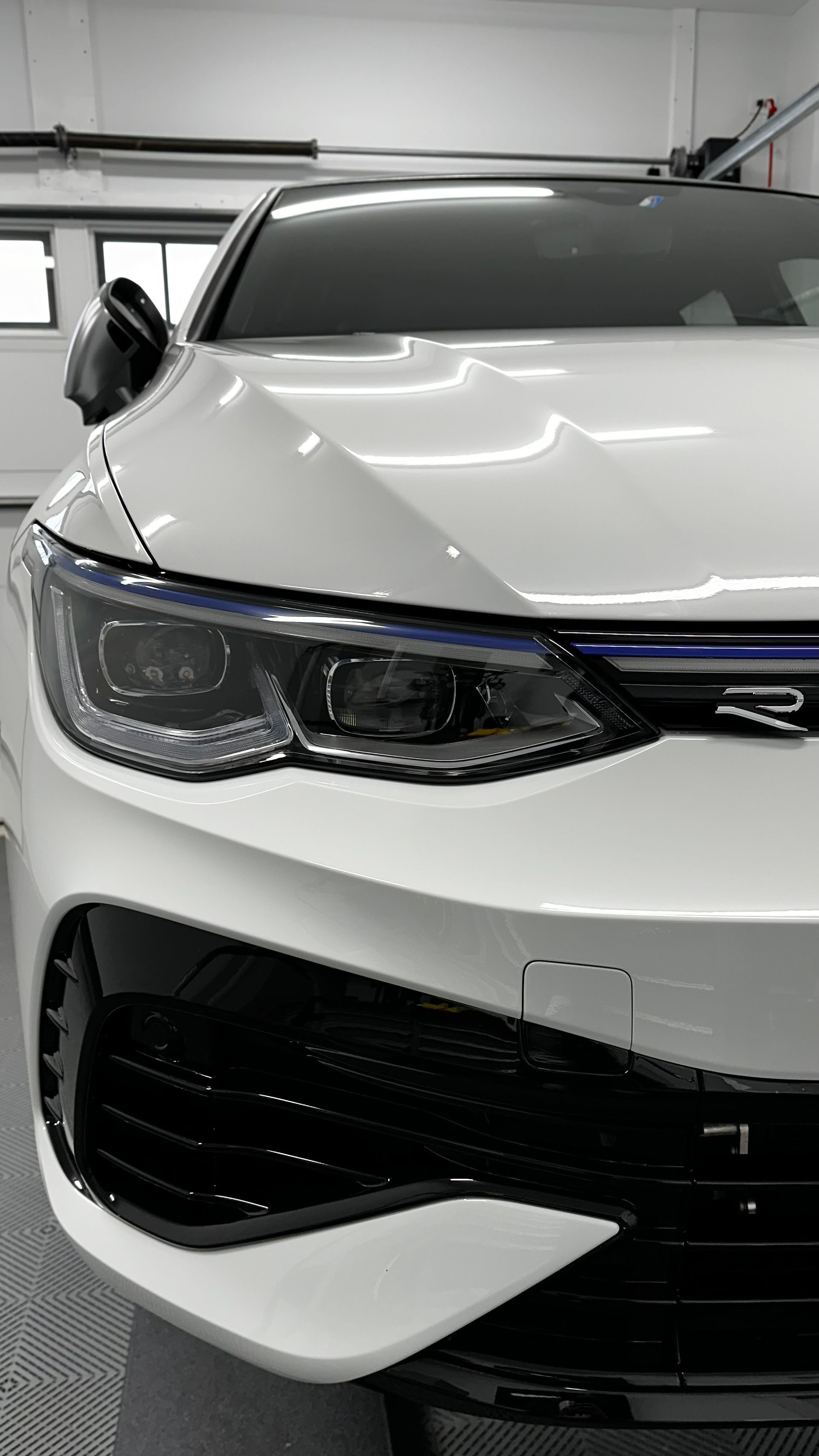 A white car is parked in a garage.